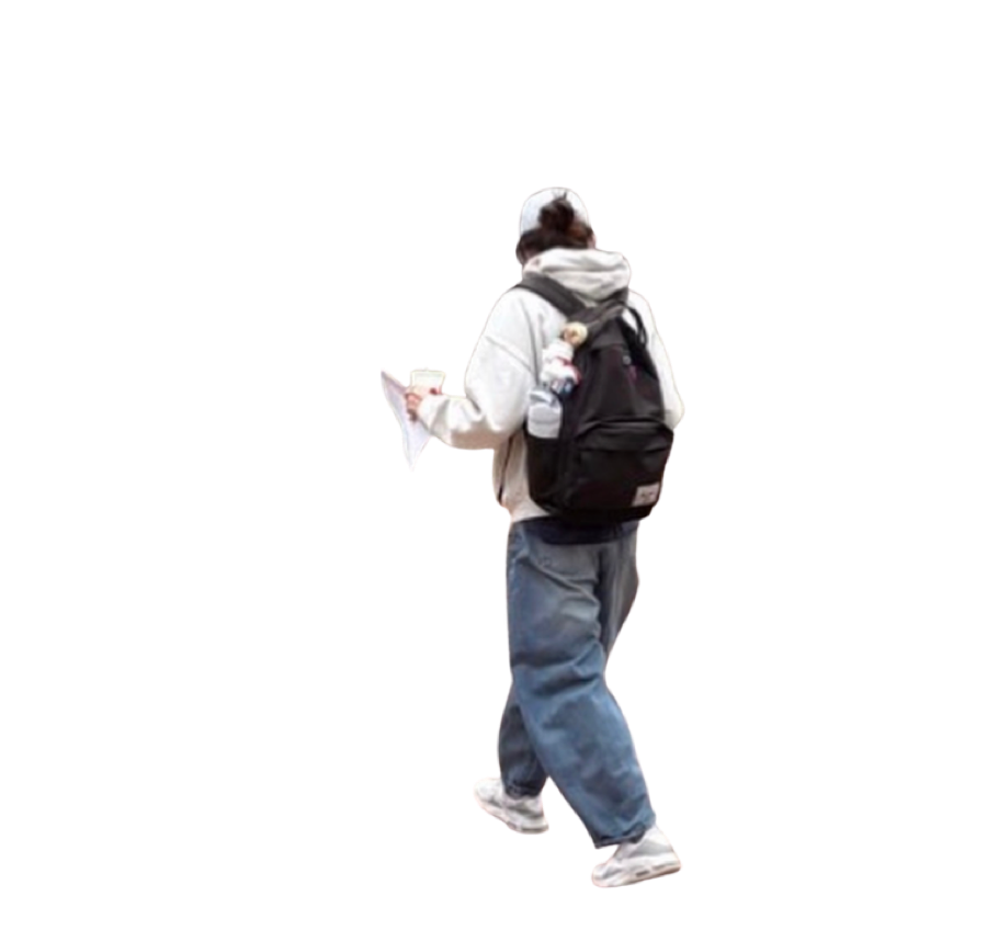 Khue walking away from the camera in a white hoodie, baggy jeans and a black backpack